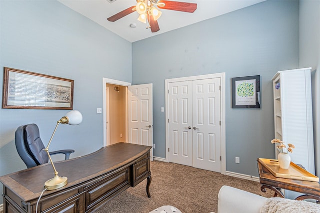 office space with baseboards, a high ceiling, a ceiling fan, and light colored carpet