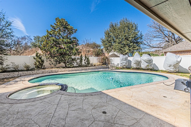 view of pool featuring a patio, a fenced backyard, and a pool with connected hot tub