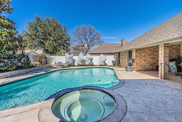 view of swimming pool with a pool with connected hot tub, a fenced backyard, and a patio