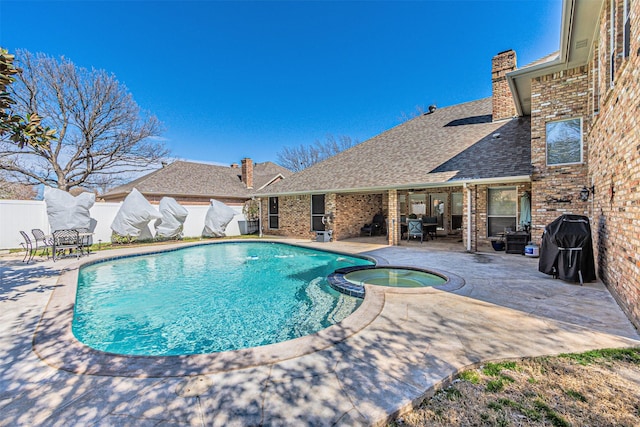 view of pool featuring a pool with connected hot tub, fence, and a patio