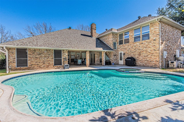 view of swimming pool with a patio area and a pool with connected hot tub