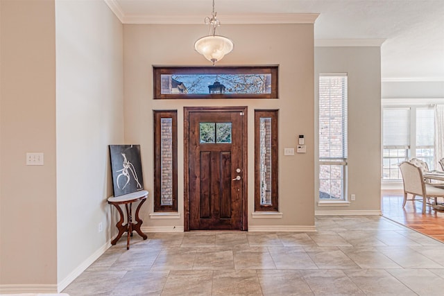 entrance foyer featuring crown molding and baseboards