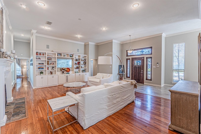 living area with recessed lighting, visible vents, baseboards, ornamental molding, and light wood-type flooring