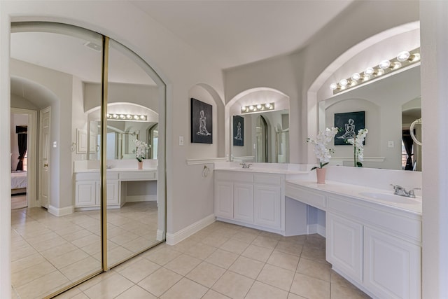 full bath featuring tile patterned flooring, connected bathroom, a sink, visible vents, and double vanity