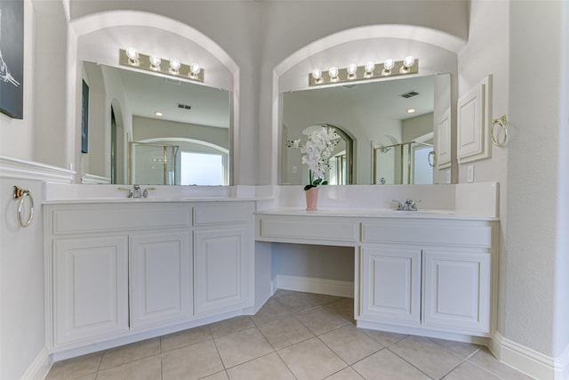 bathroom with tile patterned flooring, vanity, visible vents, baseboards, and a shower stall