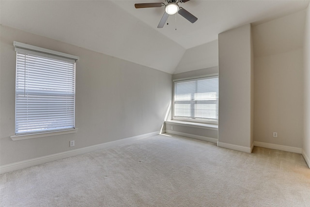 spare room featuring lofted ceiling, ceiling fan, baseboards, and light colored carpet