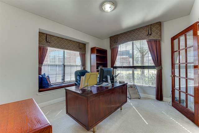 office space featuring light carpet, a wealth of natural light, and baseboards