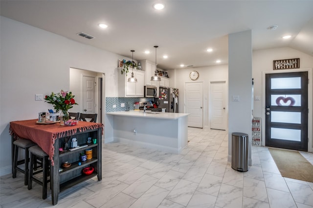 kitchen with visible vents, appliances with stainless steel finishes, a peninsula, light countertops, and white cabinetry