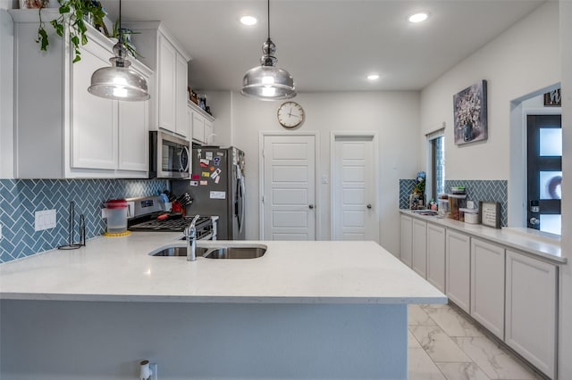 kitchen featuring stainless steel appliances, pendant lighting, light countertops, and a peninsula