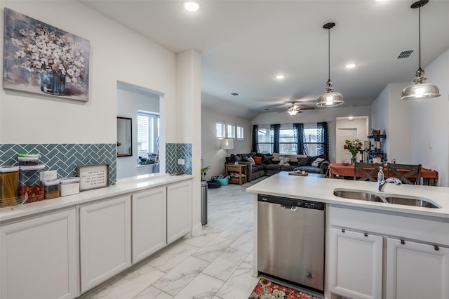 kitchen featuring pendant lighting, marble finish floor, light countertops, stainless steel dishwasher, and white cabinets