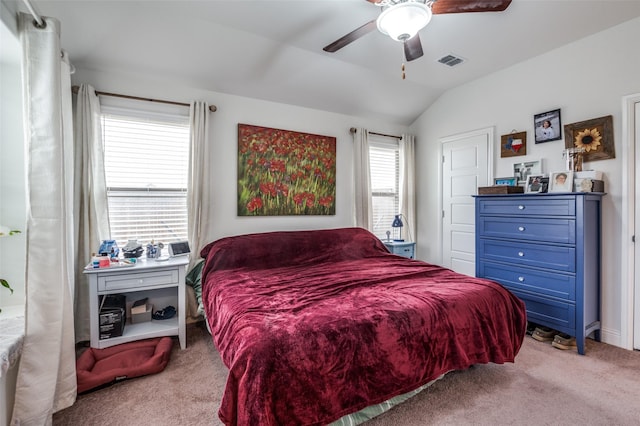 bedroom featuring ceiling fan, visible vents, vaulted ceiling, and light colored carpet