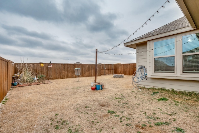 view of yard featuring an outdoor fire pit and a fenced backyard