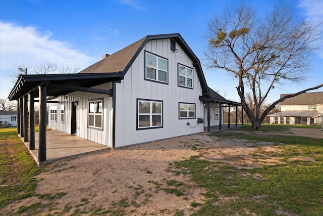 view of side of property featuring a patio and a gambrel roof