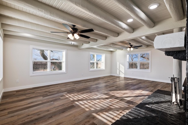 unfurnished living room featuring beamed ceiling, dark wood finished floors, and baseboards