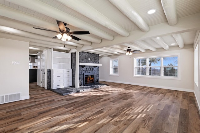 unfurnished living room featuring beam ceiling, a fireplace, dark wood finished floors, visible vents, and baseboards