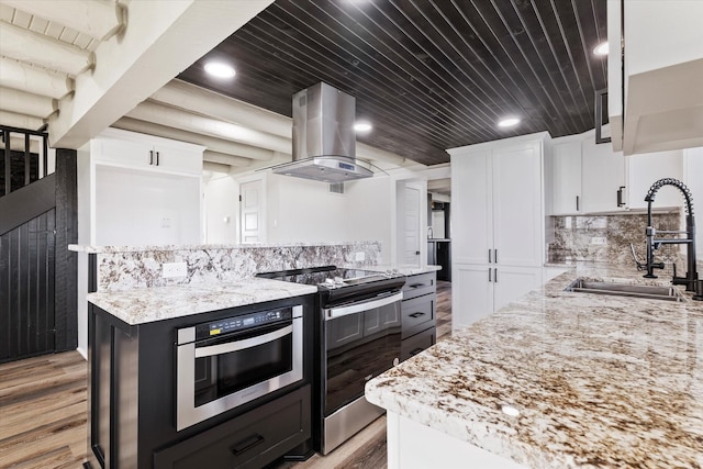 kitchen featuring light stone counters, stainless steel appliances, a sink, white cabinets, and island exhaust hood