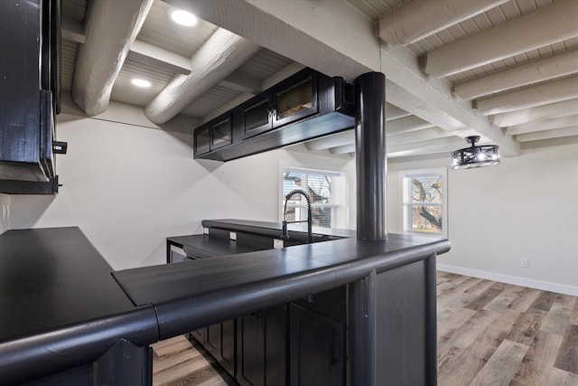 kitchen featuring baseboards, wood ceiling, light wood-style flooring, dark cabinetry, and beam ceiling