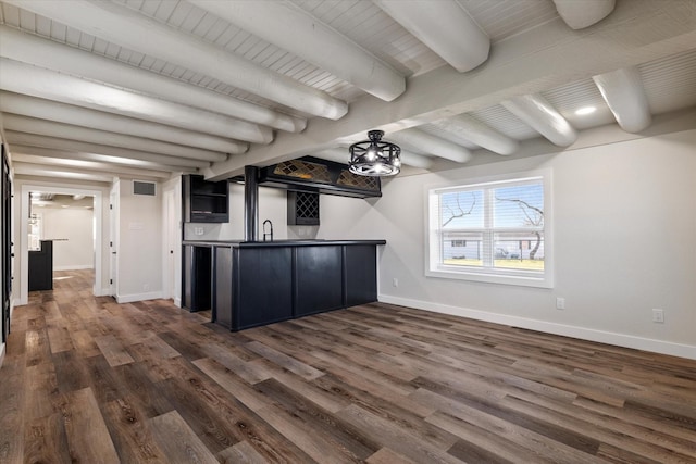 bar with dark wood-style flooring, visible vents, wet bar, beamed ceiling, and baseboards