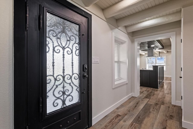 entrance foyer with beamed ceiling, wood finished floors, wood ceiling, and baseboards