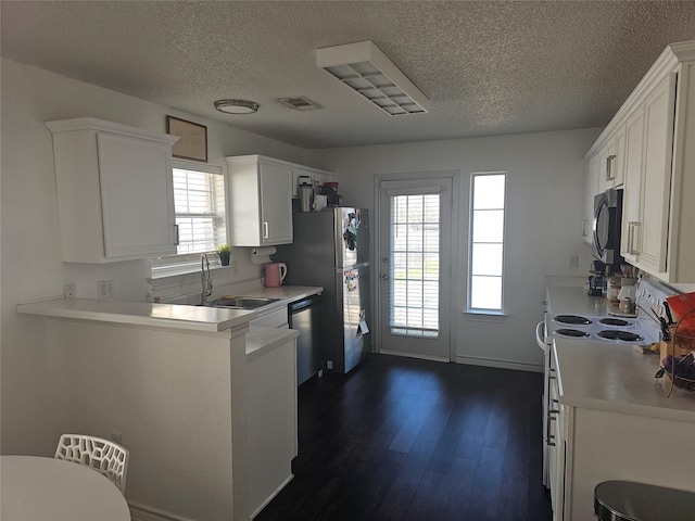 kitchen with white cabinets, appliances with stainless steel finishes, and light countertops