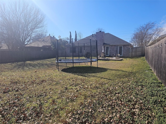 view of yard featuring a fenced backyard and a trampoline