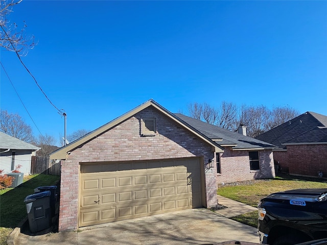 view of side of property featuring a garage, brick siding, driveway, and a chimney