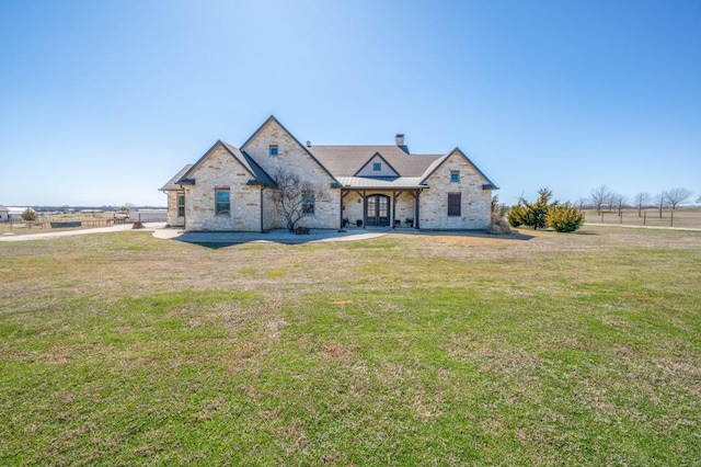 french country style house with a chimney and a front yard