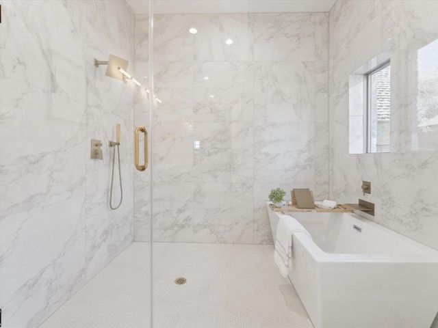 bathroom featuring a freestanding tub and a marble finish shower