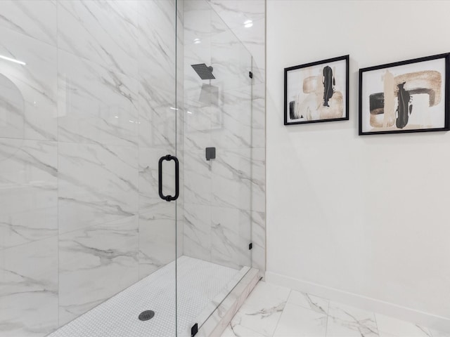 bathroom with a marble finish shower, marble finish floor, and baseboards