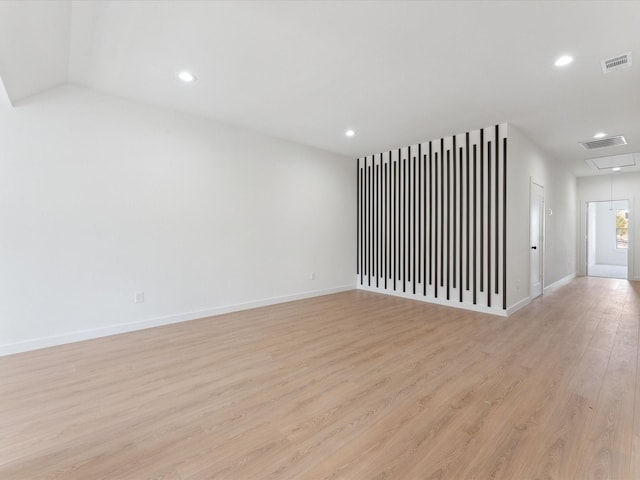 spare room featuring light wood-style floors, attic access, visible vents, and recessed lighting