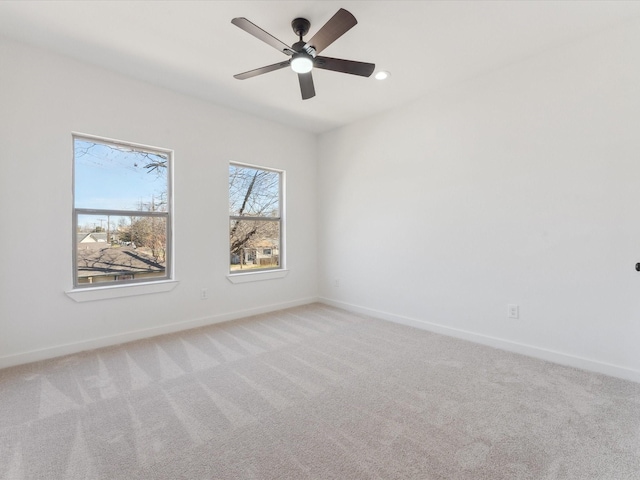 spare room with baseboards, recessed lighting, a ceiling fan, and light colored carpet