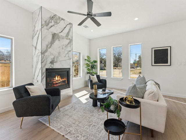 living area featuring a fireplace, recessed lighting, visible vents, light wood-style floors, and baseboards