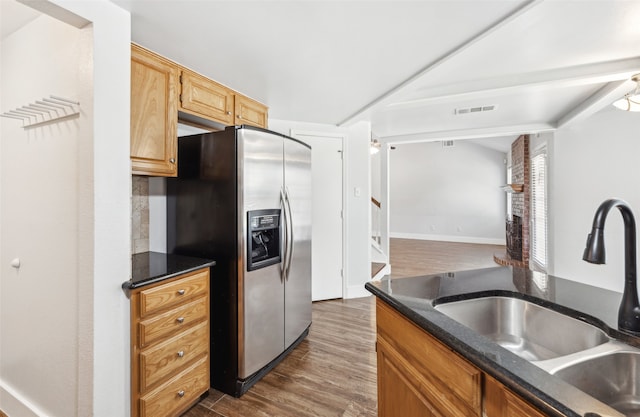 kitchen featuring dark wood-type flooring, visible vents, a sink, and stainless steel fridge with ice dispenser