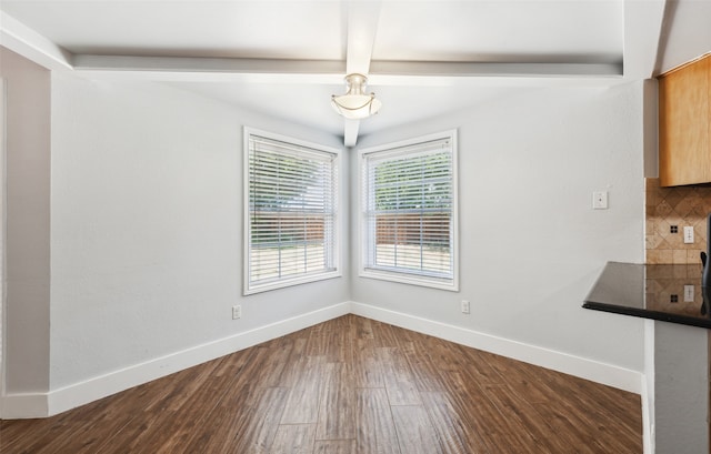 unfurnished dining area with baseboards and wood finished floors