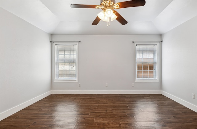 empty room with a ceiling fan, lofted ceiling, dark wood finished floors, and baseboards