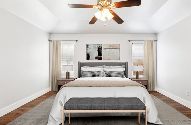 bedroom with dark wood-type flooring, multiple windows, and baseboards