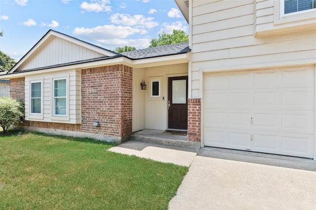 property entrance featuring a garage, driveway, brick siding, and a lawn