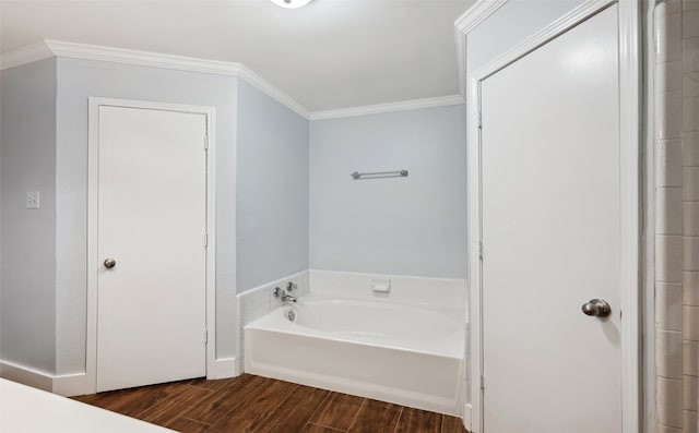 bathroom with a garden tub, crown molding, and wood finished floors