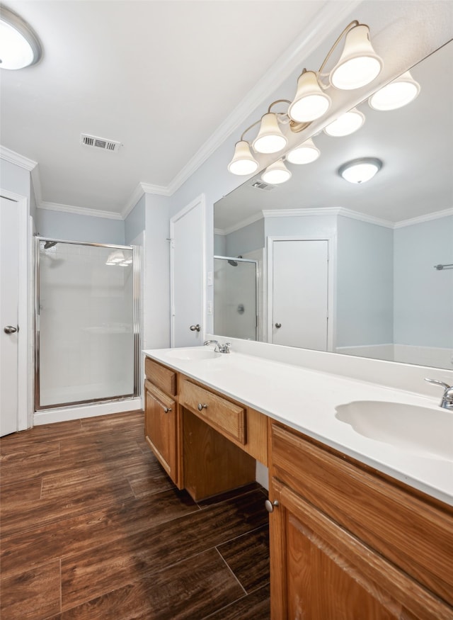 bathroom featuring ornamental molding, wood finished floors, a sink, and visible vents