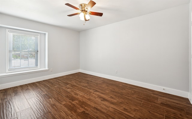 spare room with dark wood-style floors, baseboards, and a ceiling fan