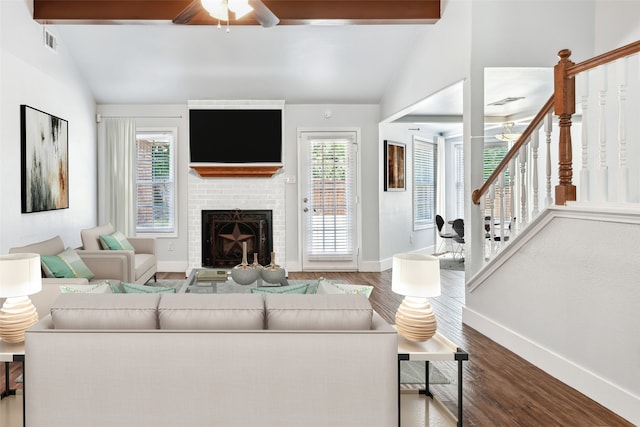 living room featuring a brick fireplace, vaulted ceiling with beams, stairway, and wood finished floors