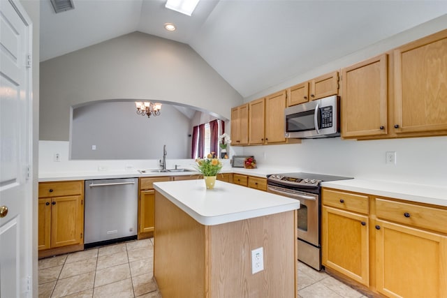 kitchen featuring stainless steel appliances, light countertops, a sink, and a kitchen island