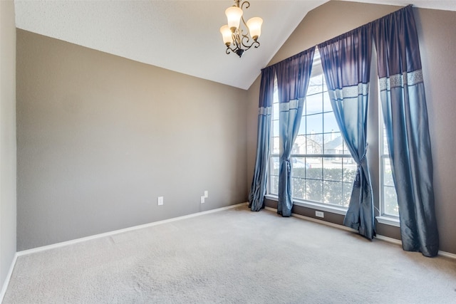 empty room with lofted ceiling, baseboards, a chandelier, and carpet flooring