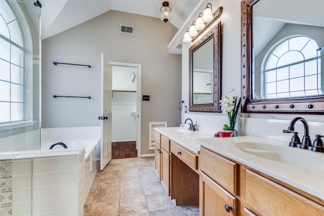 bathroom featuring lofted ceiling, a healthy amount of sunlight, and a sink