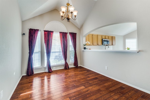 unfurnished room featuring arched walkways, lofted ceiling, a notable chandelier, dark wood-style flooring, and baseboards