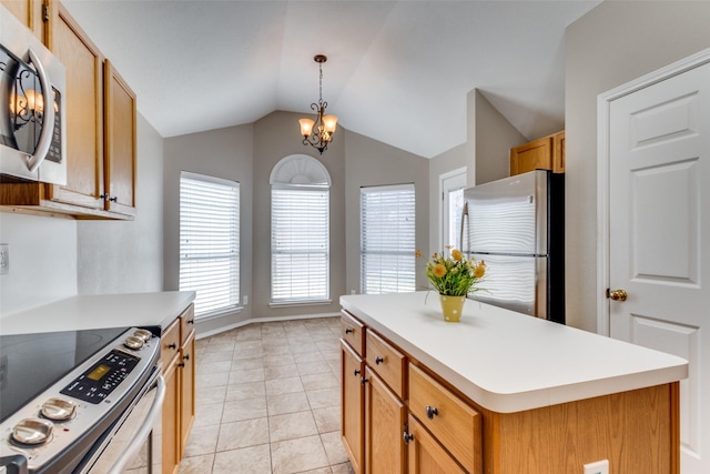 kitchen featuring light countertops, appliances with stainless steel finishes, a kitchen island, and decorative light fixtures