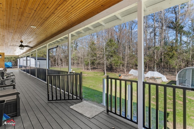 deck featuring an outbuilding, ceiling fan, fence, a yard, and a shed