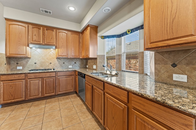 kitchen featuring visible vents, appliances with stainless steel finishes, stone counters, under cabinet range hood, and a sink