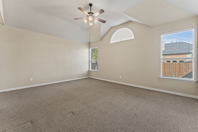 carpeted spare room featuring vaulted ceiling, a ceiling fan, and baseboards