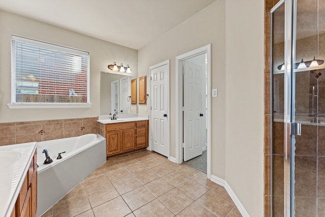 full bathroom with baseboards, tile patterned floors, vanity, a shower stall, and a bath